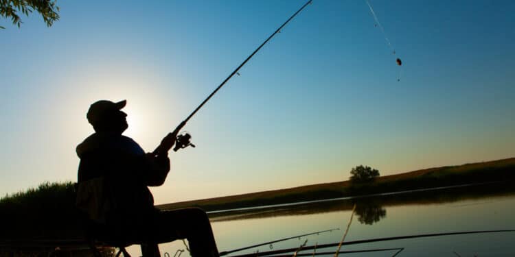 Pescador lança a vara à beira da água ao entardecer, retratando os pescadores do semiárido