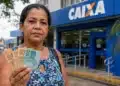 Mulher segurando dinheiro em frente a uma agência da Caixa Econômica Federal, representando a solicitação do valor de R$ 2.900 do PIS/Pasep