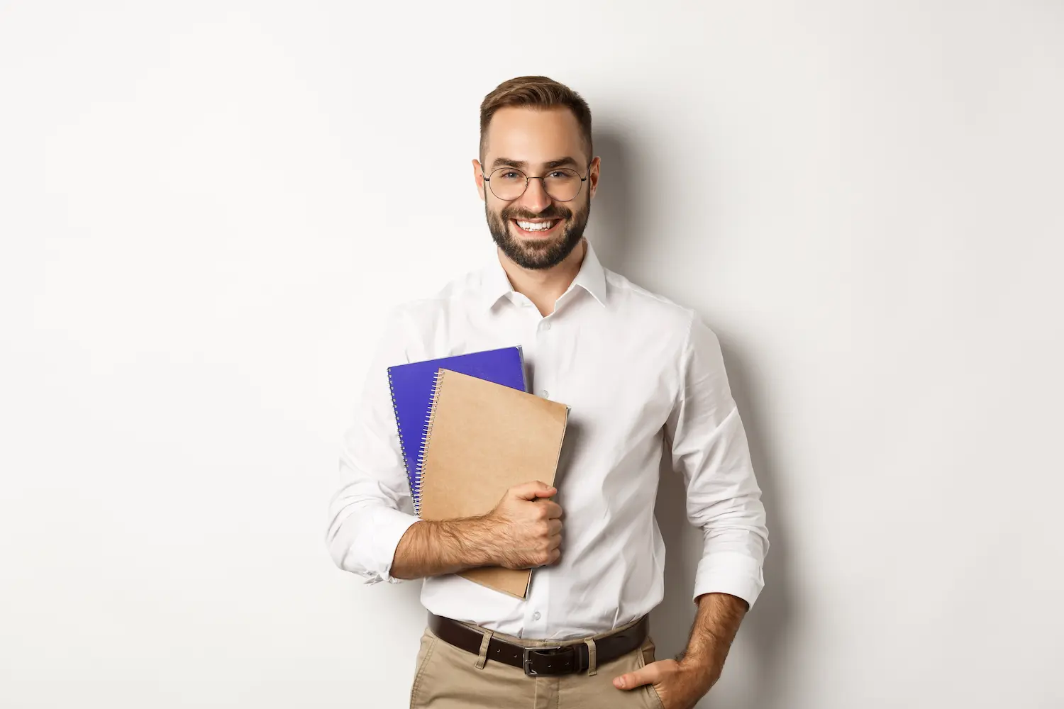 PND 2026 Homem sorridente segurando cadernos, representando estudante ou docente em contexto de preparação para a Prova Nacional Docente (PND).