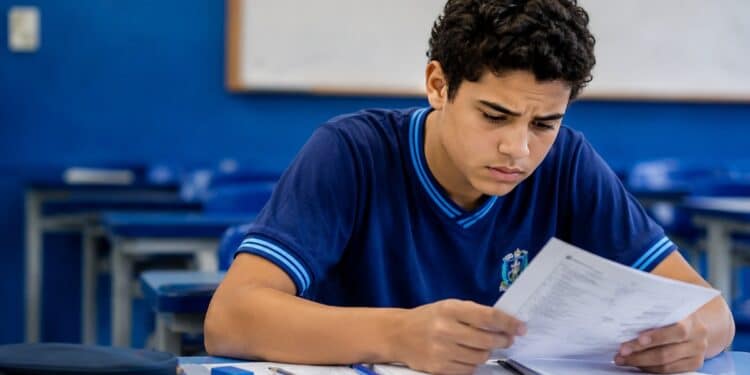 Candidato do Enem 2026 analisa uma folha em sala de aula, ilustrando a verificação do pedido de atendimento especializado dentro do prazo de recurso