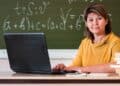 Professora ao computador em sala de aula representa as áreas avaliadas na Prova Nacional Docente 2026