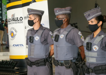 Três policiais militares de São Paulo, uniformizados e com coletes, em evento oficial do governo estadual