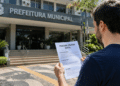Homem lendo edital de processo seletivo em frente à Prefeitura Municipal em Santa Catarina.