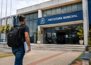 Homem com mochila caminhando em direção à Prefeitura Municipal, representando processo seletivo com inscrições abertas.