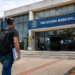 Homem com mochila caminhando em direção à Prefeitura Municipal, representando processo seletivo com inscrições abertas.