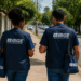 Dois agentes do IBGE caminhando em rua residencial durante trabalho de campo de pesquisa estatística.