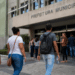 Pessoas em frente à prefeitura municipal aguardando atendimento em processo seletivo com vagas abertas.