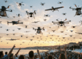 Dezenas de drones sobrevoam uma orla movimentada ao pôr do sol, ilustrando o crescimento do mercado e da profissão de piloto de drone