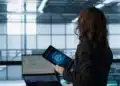 Profissional analisando tecnologia de inteligência artificial em ambiente corporativo moderno, simbolizando novas carreiras com altos salários.