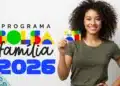 Mulher brasileira segurando cartão do Bolsa Família com cédulas de real simbolizando pagamento de R$ 1.000 em 2026