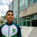 Jovem de agasalho esportivo do Brasil em frente a um prédio público