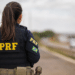 Agente da Polícia Rodoviária Federal de costas em rodovia.