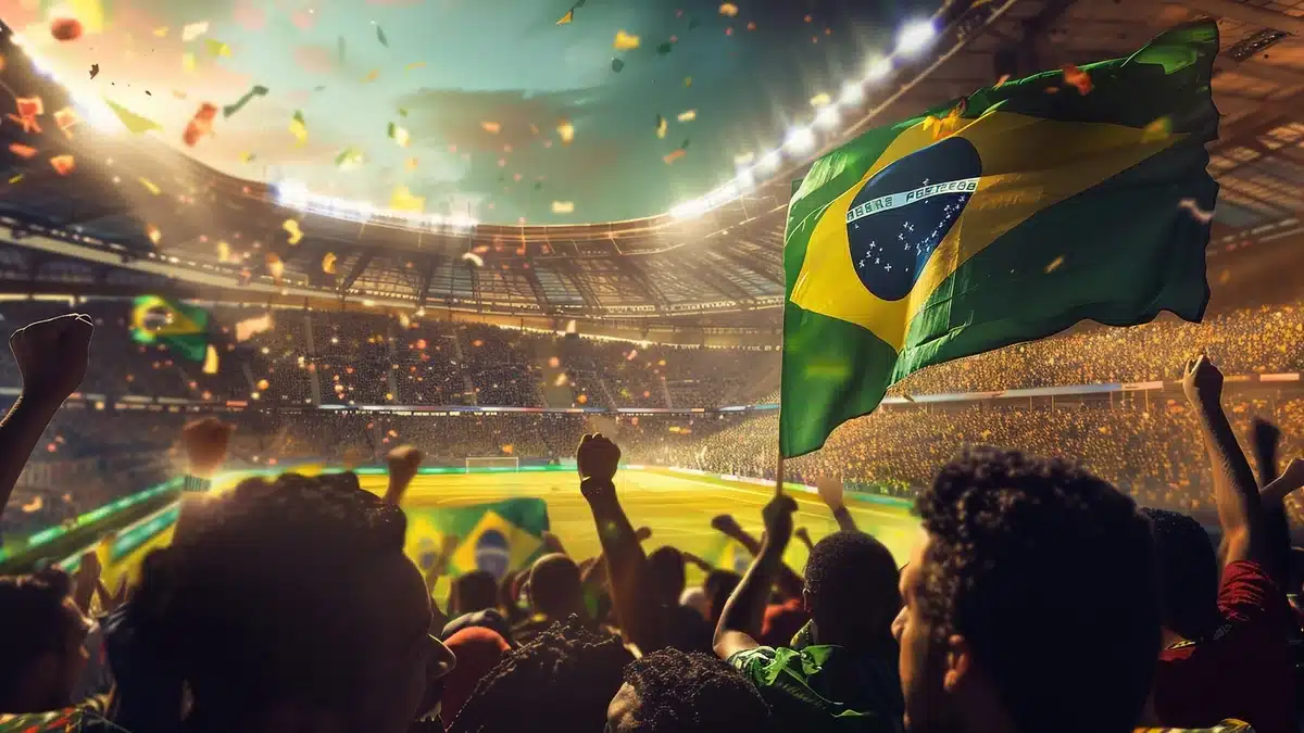 Torcedores brasileiros comemoram em estádio com a bandeira do Brasil, representando os próximos jogos da seleção na Copa do Mundo de 2026.