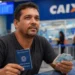 Trabalhador brasileiro segura carteira de trabalho e dinheiro em agência da Caixa, representando o ressarcimento do PIS/Pasep
