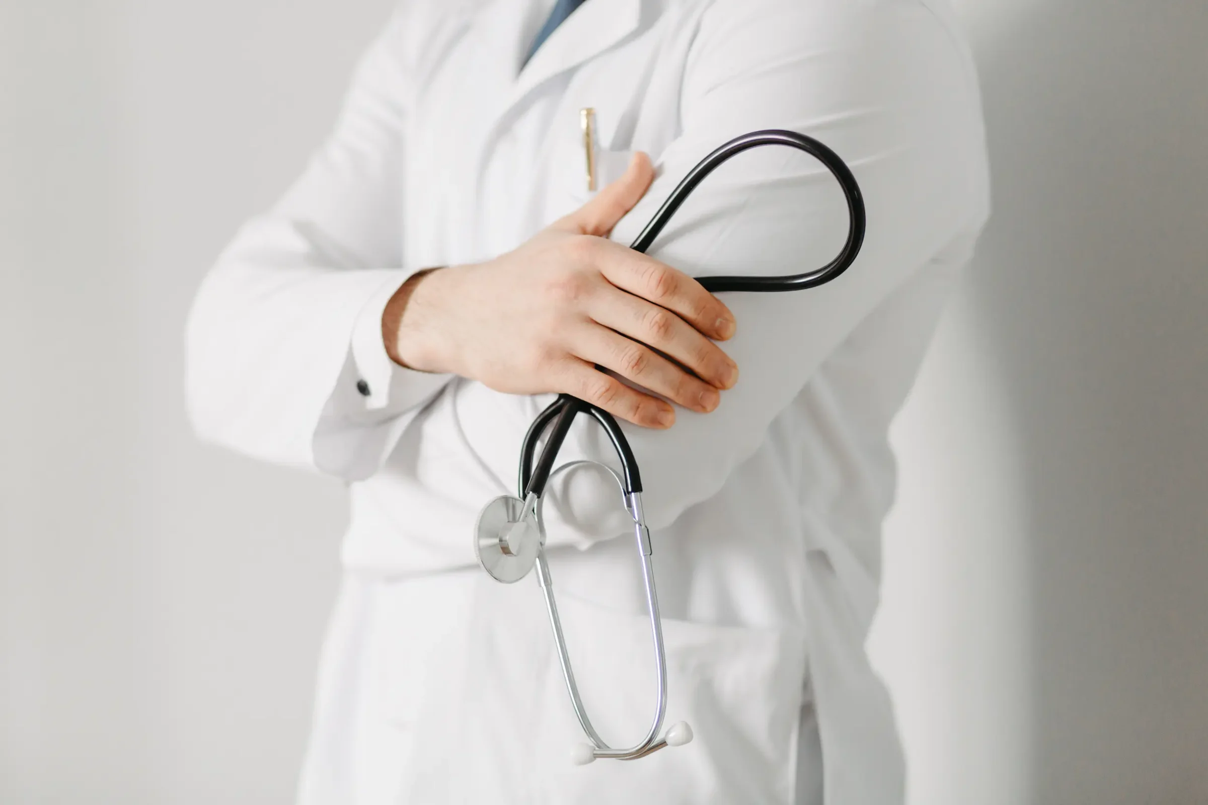 Médico segurando prancheta e estetoscópio, representando o cronograma completo do Revalida 2026/2.