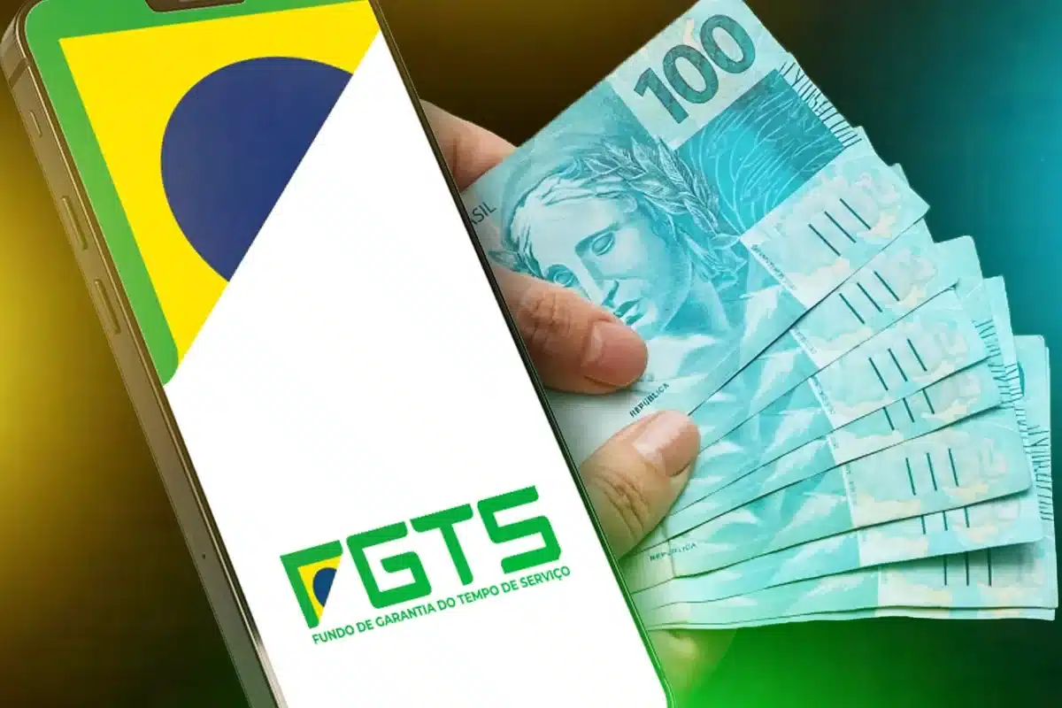 Pessoa acessa o aplicativo FGTS no celular enquanto segura notas de R$ 100, representando o processo de solicitação do Saque Calamidade.