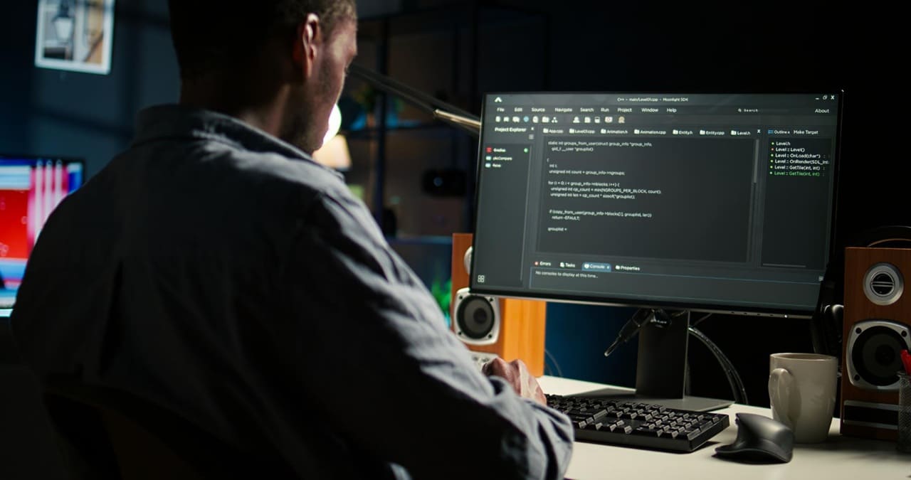 Programador trabalha em código durante a noite, retratando o esforço técnico contínuo que dificulta a coordenação global da inteligência artificial