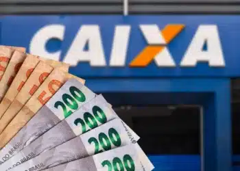 Dinheiro em notas de real em frente a uma agência da Caixa Econômica Federal, representando a solicitação do saque de R$ 6.220.