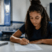 Jovem mulher preenchendo formulário de inscrição em concurso público em ambiente de estudo.