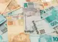 Notas de real brasileiro representando o pagamento do abono anual do INSS em 2026.