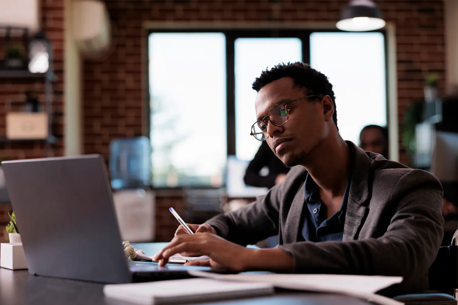 Aprendizado contínuo e desenvolvimento profissional Profissional utiliza notebook no escritório durante atividade de aprendizado e atualização de competências.