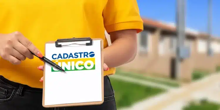 Mulher de blusa amarela segurando prancheta com nome "Cadastro Único".