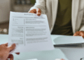Entrevista de emprego com entrega de currículo no escritório.