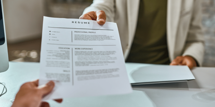 Entrevista de emprego com entrega de currículo no escritório.