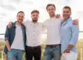 Grupo de homens reunidos ao ar livre representando a celebração do Dia dos Homens em 15 de julho.