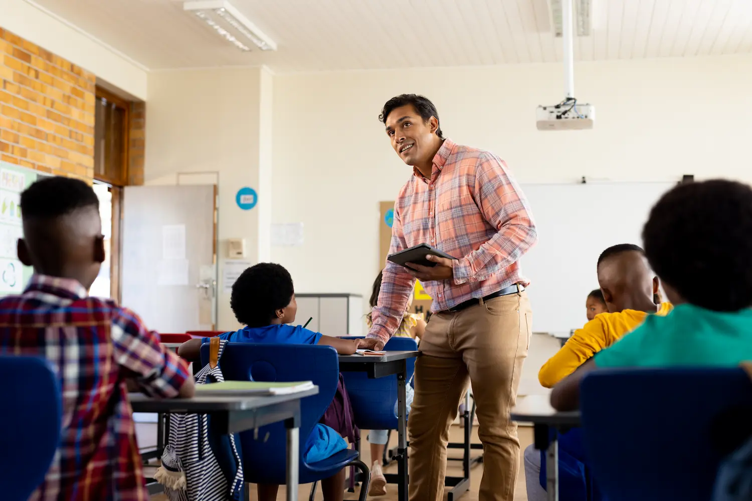 Escolas deverão incluir educação política e direitos da cidadania no currículo Professor ministrando aula para estudantes em sala de ensino com foco em educação e cidadania.