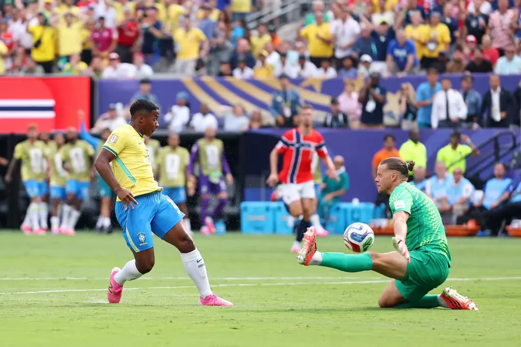 Endrick Endrick tenta finalizar diante do goleiro Orjan Nyland durante Brasil x Noruega na Copa do Mundo de 2026.