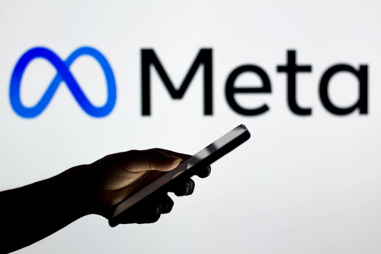 Meta Logo da Meta ao fundo com celular em destaque, representando o fim da ferramenta de inteligência artificial que utilizava fotos de perfis públicos do Instagram.