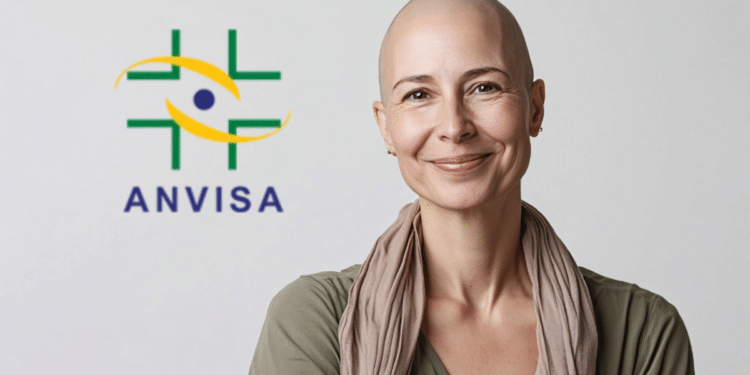 Mulher adulta careca sorri ao lado do logo da ANVISA em fundo claro.
