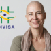 Mulher adulta careca sorri ao lado do logo da ANVISA em fundo claro.