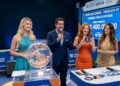 Quatro apresentadores mostram a bola sorteada número 3 na Loteria dos Sonhos em estúdio decorado