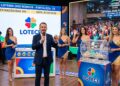 Apresentador e assistentes exibem bolas do sorteio da Loteria dos Sonhos com resultado das 14h em estúdio colorido