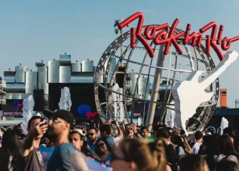 Público reunido na entrada do Rock in Rio, diante da estrutura com o logotipo e a guitarra do festival.