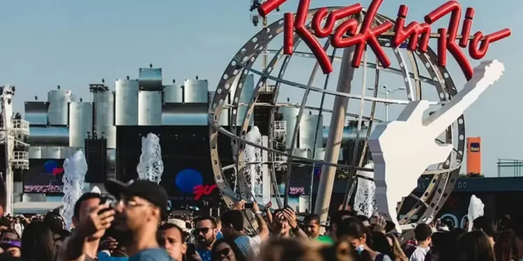 Público reunido na entrada do Rock in Rio, diante da estrutura com o logotipo e a guitarra do festival.