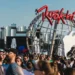 Público reunido na entrada do Rock in Rio, diante da estrutura com o logotipo e a guitarra do festival.