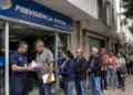 Fila de segurados em frente a uma agência do INSS, representando o atendimento extraordinário de serviços previdenciários.