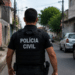 Policial da Polícia Civil de Alagoas caminhando em rua urbana durante operação.