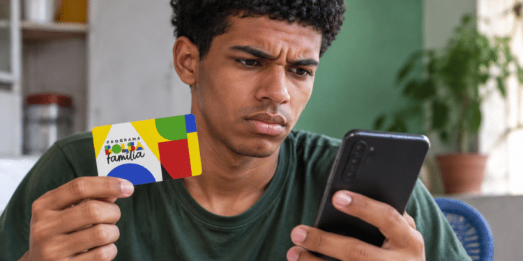 Beneficiário segurando cartão do Bolsa Família e consultando informações no celular.