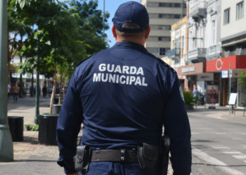 Guarda municipal fardado, visto de costas em área urbana, representando o concurso da Guarda Municipal de Itupeva.