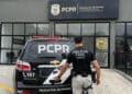 Policial civil do Paraná em frente à viatura e à unidade da PCPR.