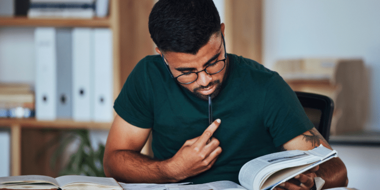 Candidato estudando para concursos públicos com livros e materiais de preparação.