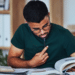 Candidato estudando para concursos públicos com livros e materiais de preparação.
