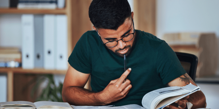 Pessoa estudando para concursos públicos com livros e materiais de preparação para vagas em Câmaras Municipais.