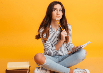 Jovem estudante com caderno e lápis se preparando para concursos de nível médio em 2026.