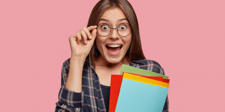 Pessoa surpresa segurando materiais de estudo para concurso público.
