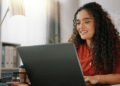 Mulher acessando um notebook para consultar concursos de Prefeituras com salários de até R$ 16.590,03.